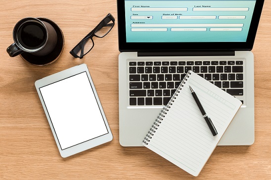 Laptop, mobile phone, a pair of glasses and a cup of coffee.