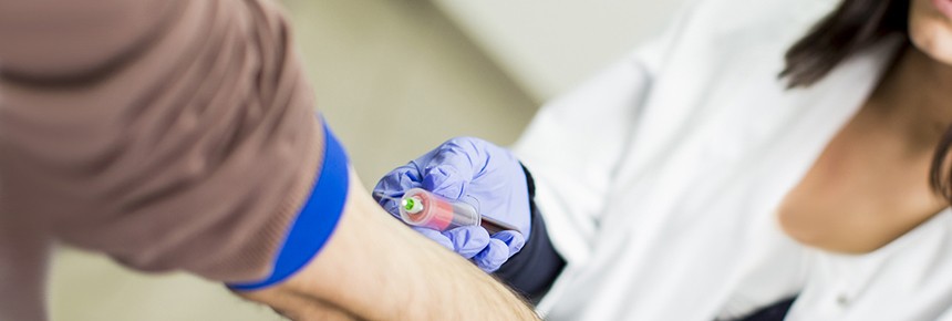 partially shown nurse drawing blood from man's arm