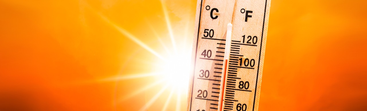 Bright sun with high temperatures shown on thermometer in Celcius and Farenheit