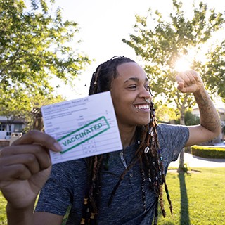 black man holding CDC COVID-19 vaccination card