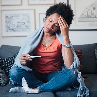 Sick woman checking thermometer